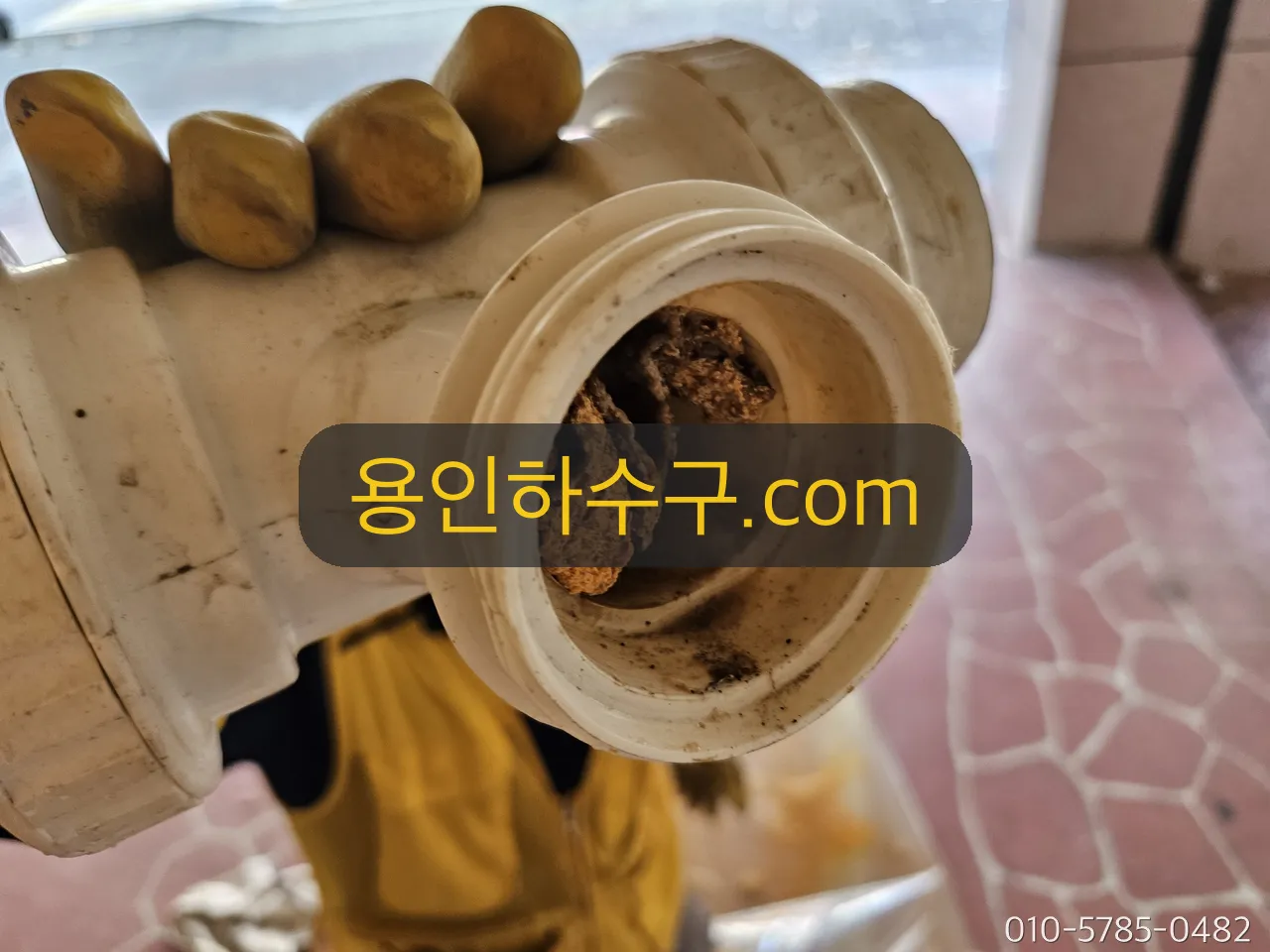 떼어낸 배관 단면 — 기름때로 가득 막힌 상태