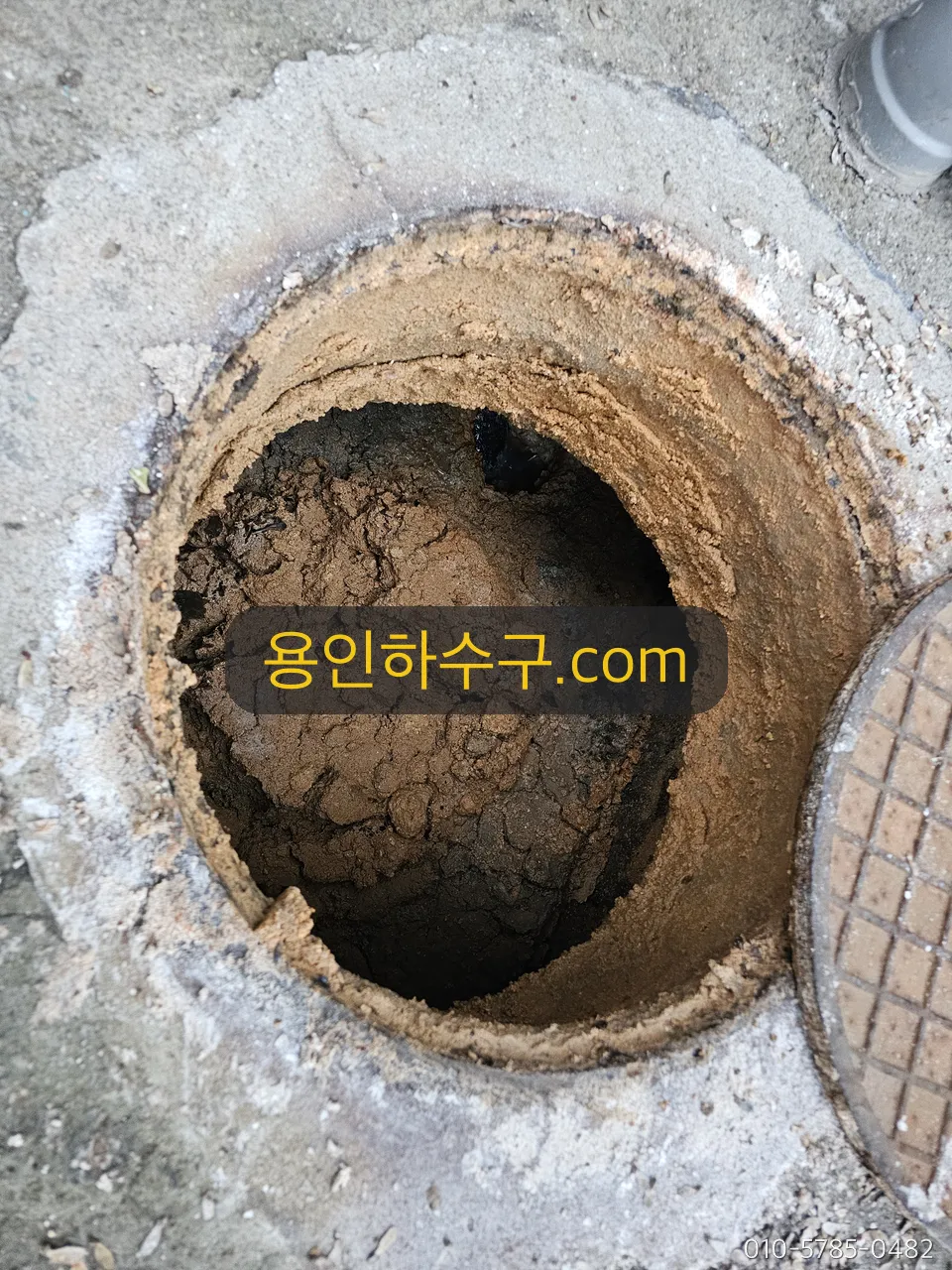 퇴적물로 가득 찬 맨홀 내부 — 작업 전
