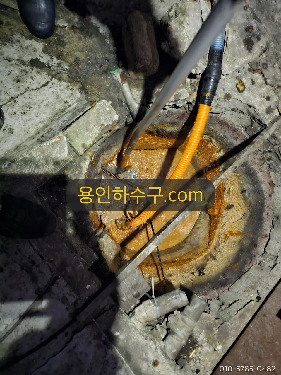 맨홀에 고압 호스를 넣어 관로를 세척하는 작업